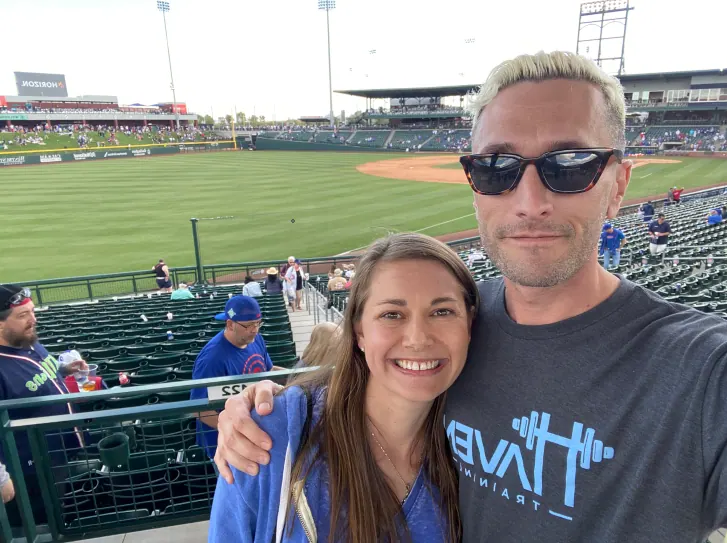 Molly and a friend taking a selfie in the stands at a baseball stadium