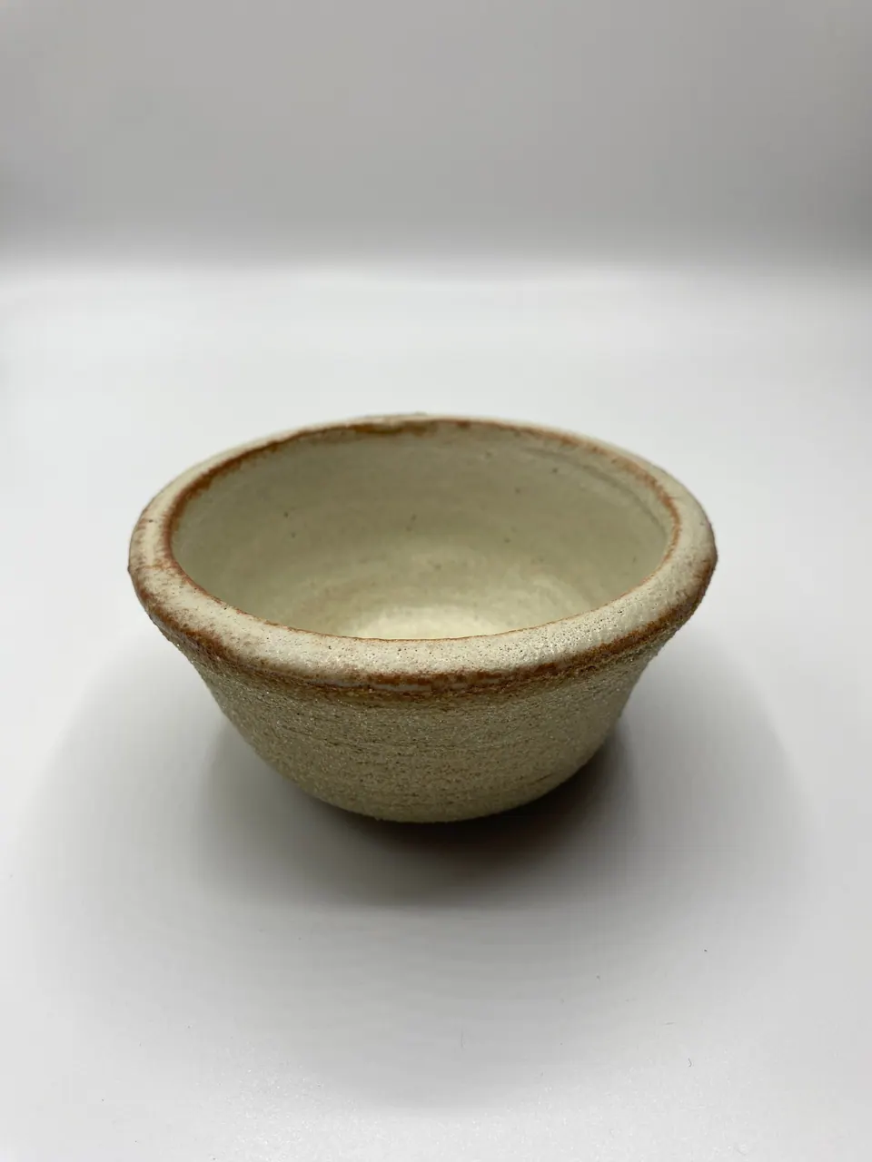 Small unglazed-rim ceramic bowl in a soft oatmeal cream