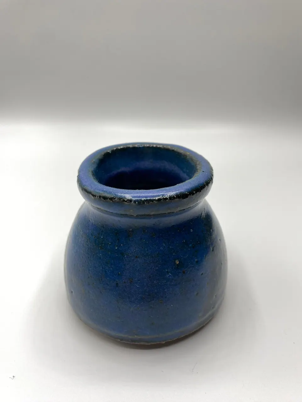 Bulbous ceramic vase with a flared neck in a deep matte blue glaze